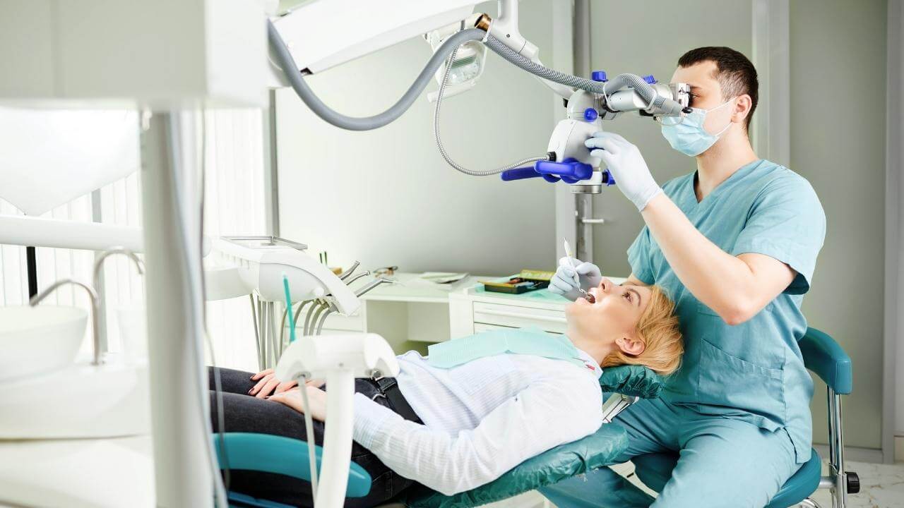 רופא שיניים מבצע טיפול שורש מיקרוסקופי